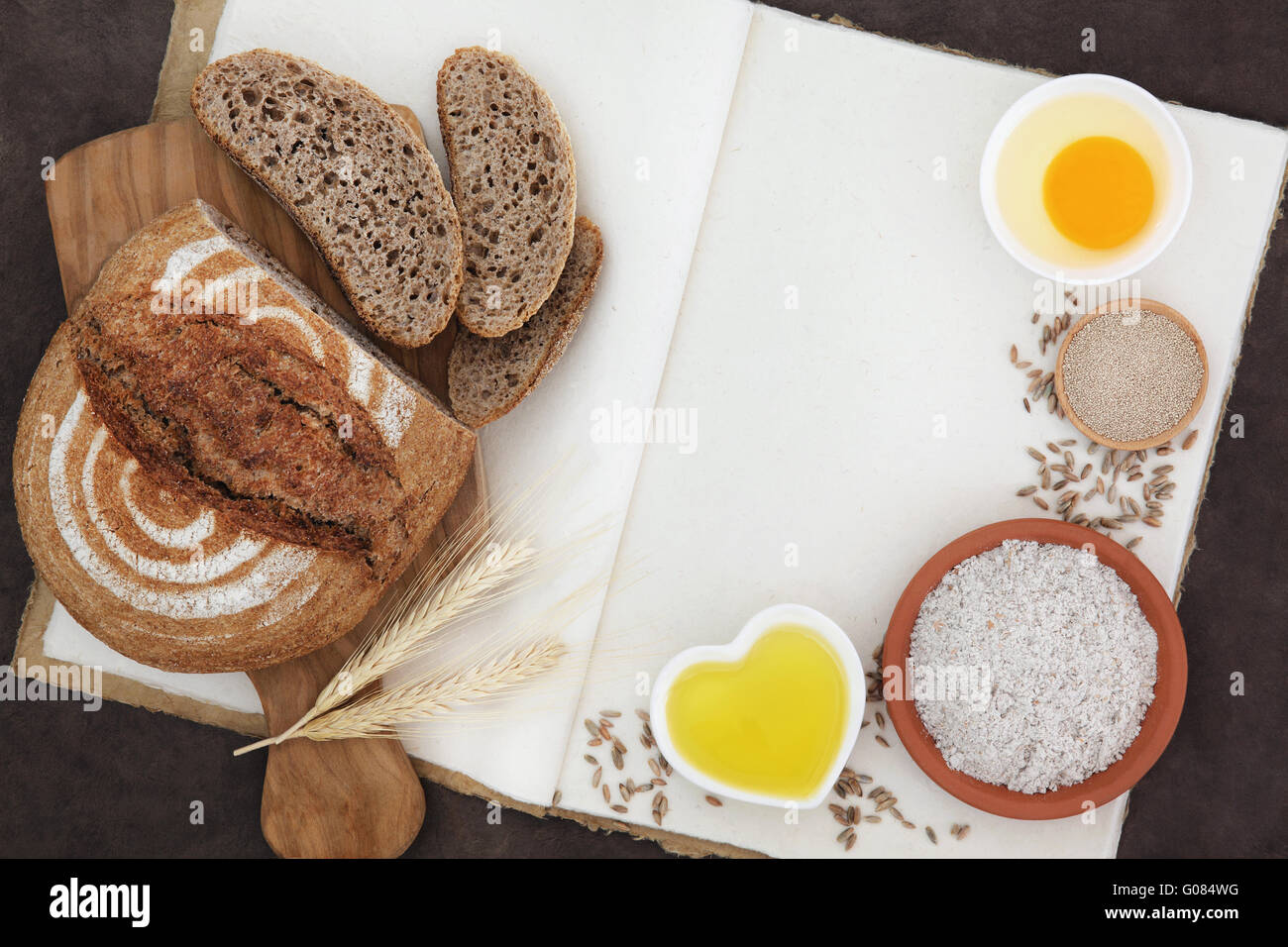 Rustic rye bread loaf with baking ingredients and wheat sheaths with ...