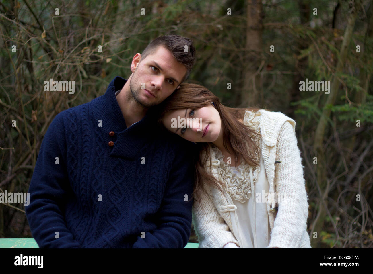 Young couple in the forest head on head in front of trees and plants Stock Photo