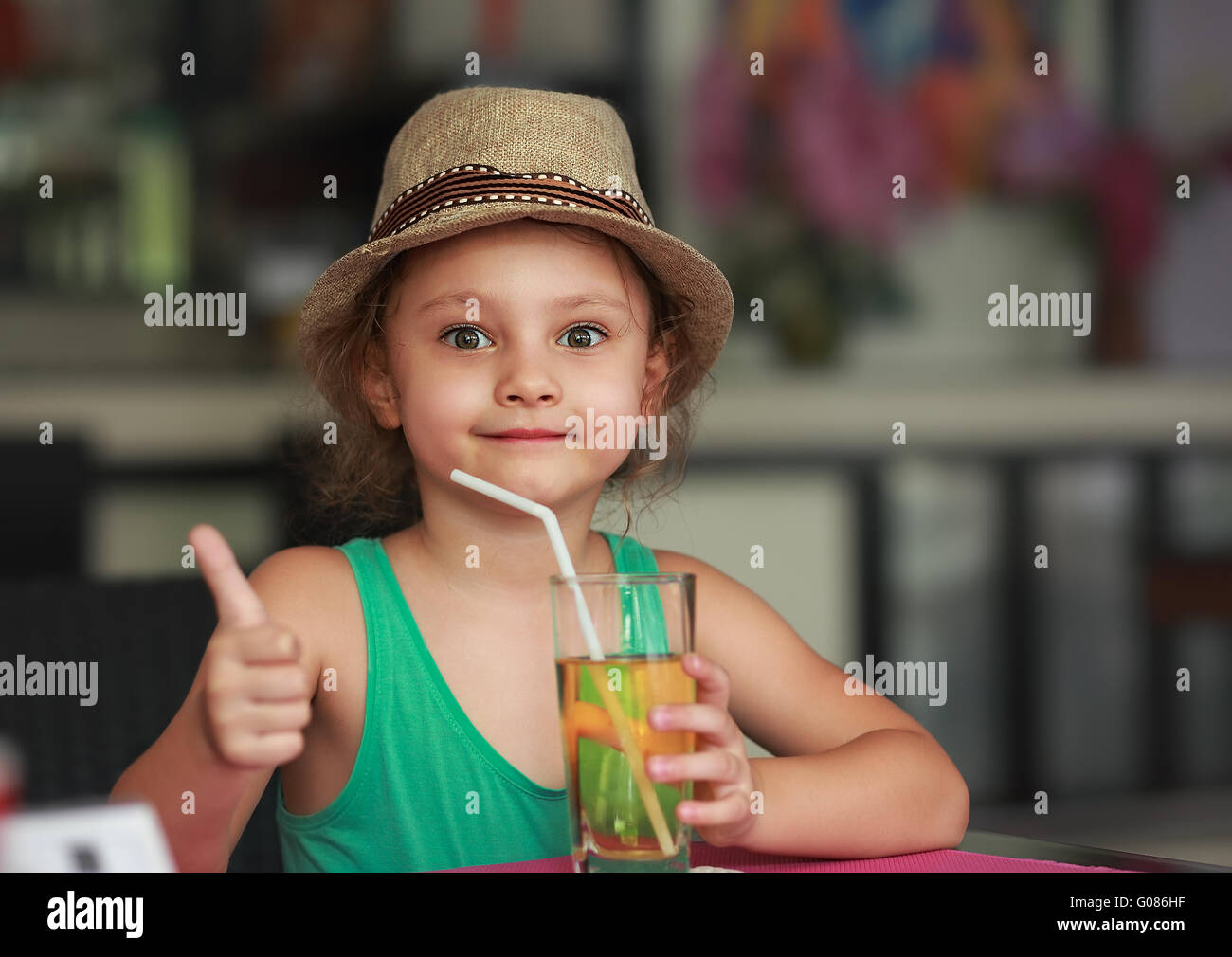 Happy Kid Girl Drinking Apple Juice In Restaurant And Showing