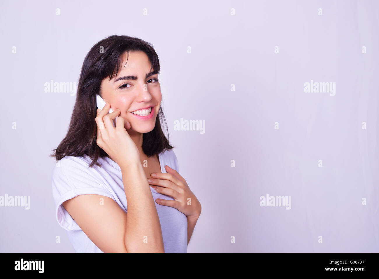 Portrait of hispanic young woman using a mobile phone. Woman talking on ...