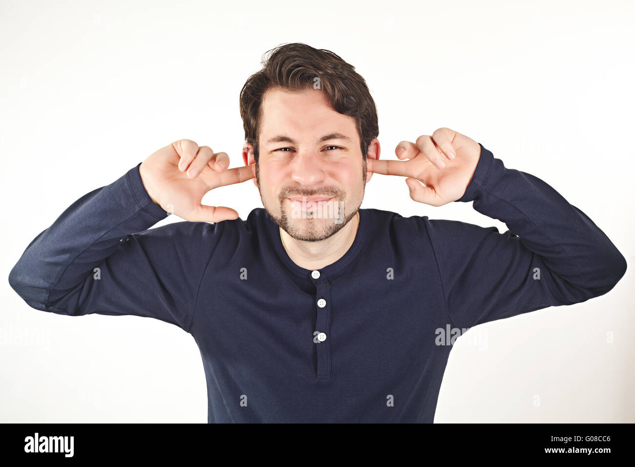 young man covering ears from loud noise, isolated on white background Stock Photo