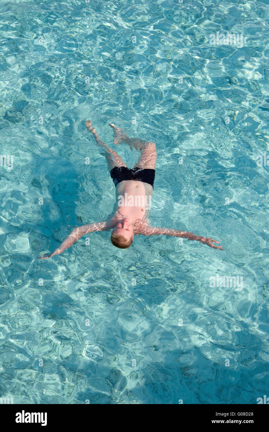 boy has a rest on transparent water of ocean Stock Photo