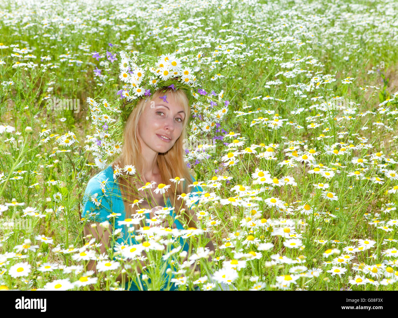 happy young woman in a wreath from wild flowers Stock Photo