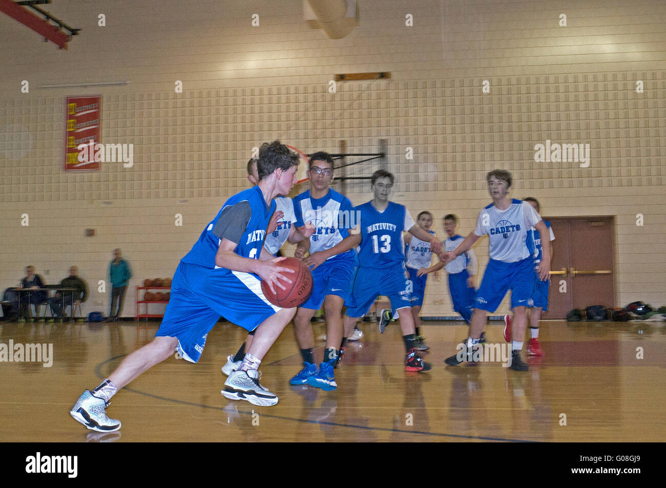 Young teenage boy age 13 dribbles basketball for Nativity Catholic School during a conference game. St Paul Minnesota MN USA Stock Photo