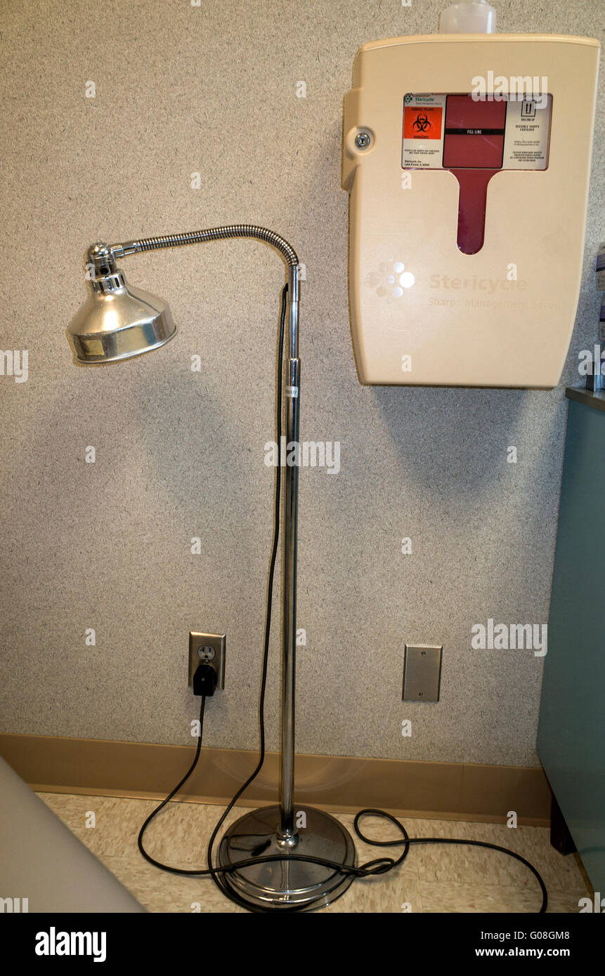 Doctor's office goose neck examination light and Stericycle for safely collecting used needles. Minneapolis Minnesota MN USA Stock Photo