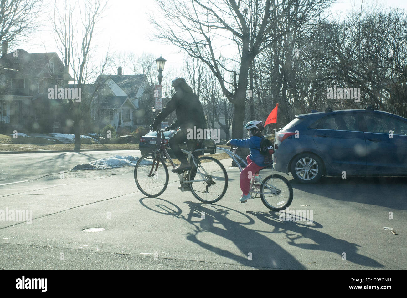 Father and daughter riding tandem bicycle with orange warning flag. St Paul Minnesota MN USA Stock Photo