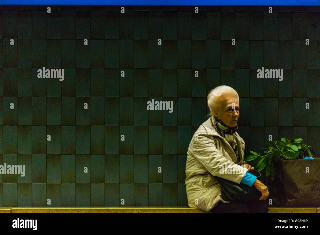 Old Lady waiting for a train in Sagrada Família Station, Barcelona, Catalonia, Spain Stock Photo