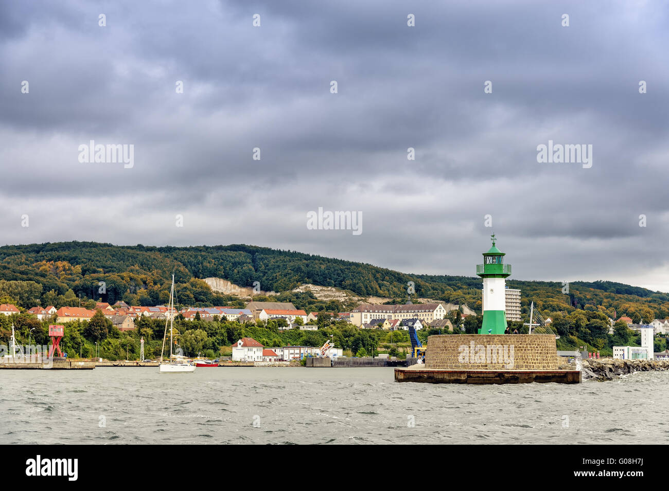 Port entrance with lighthouse pier and the town of Stock Photo