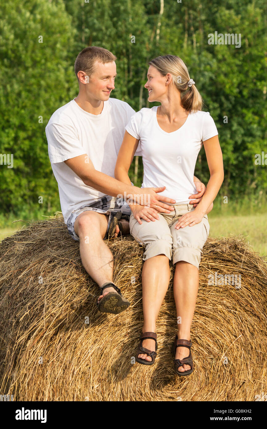Two young lovers on haystack Stock Photo
