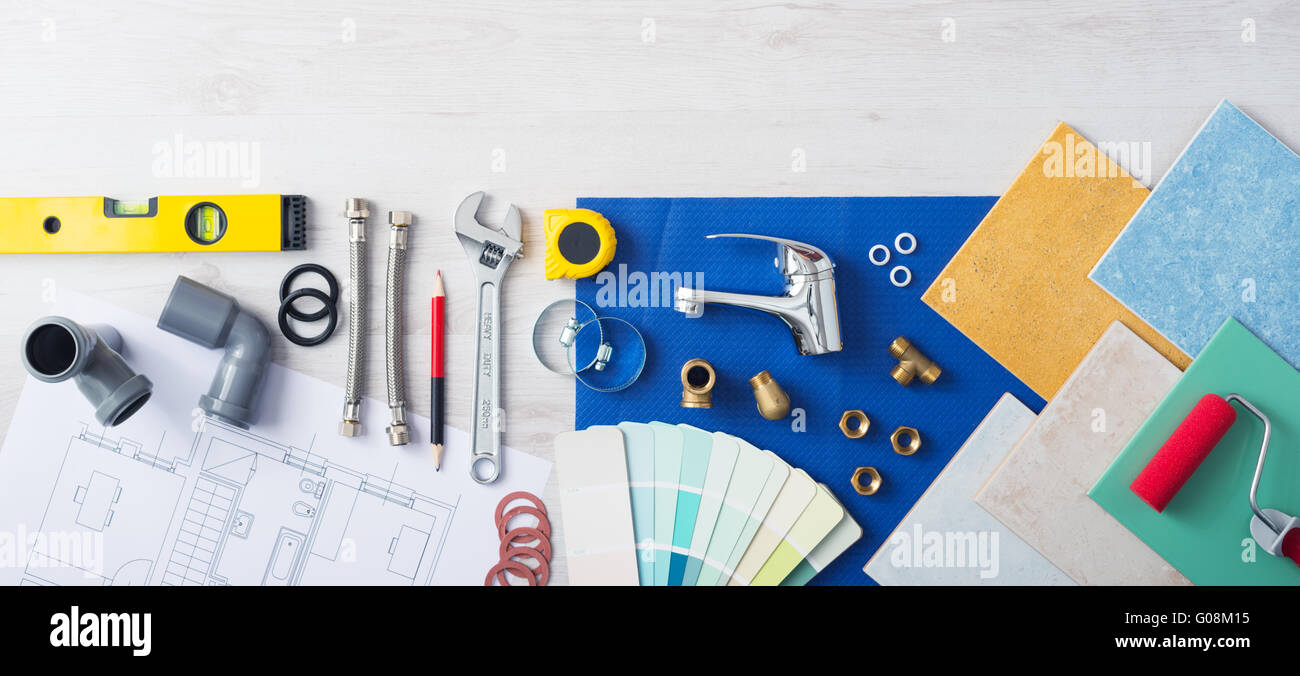 Plumber's work table banner with work tools, faucet, tiles and color swatches, top view Stock Photo