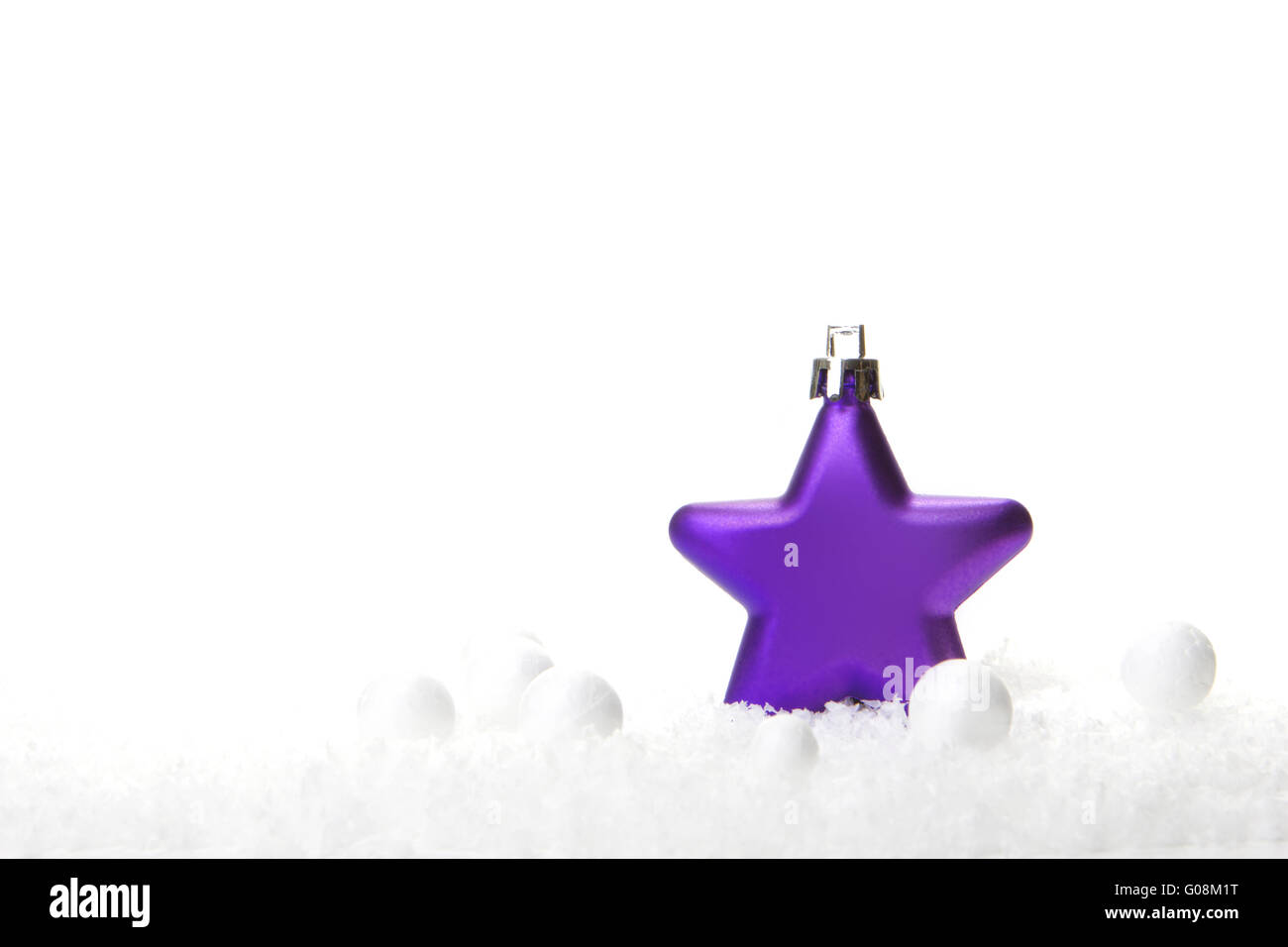 purple christmas bauble as christmas star on snow Stock Photo