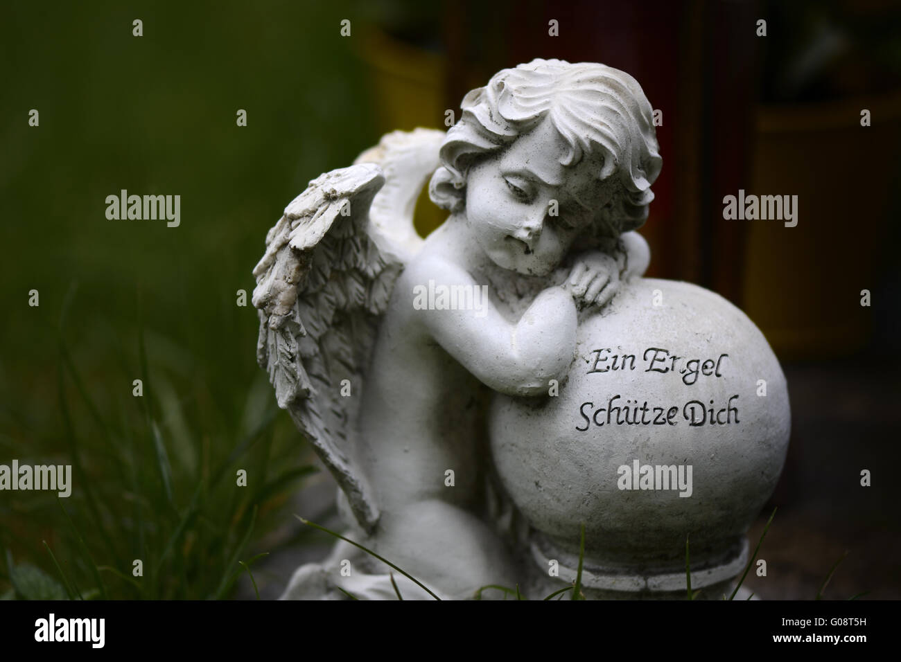 Marble angel with ball and quote: An Angel Shelter Stock Photo