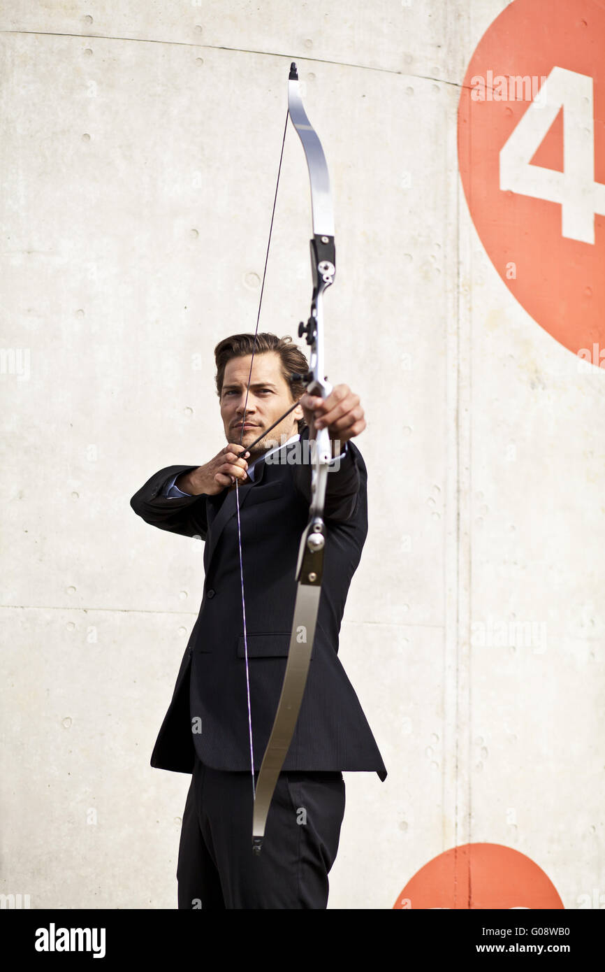 Businessman aiming bow and arrow Stock Photo Alamy