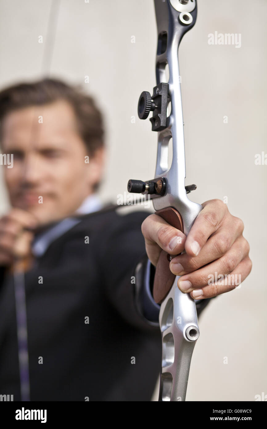 Determined businessman aiming bow Stock Photo - Alamy