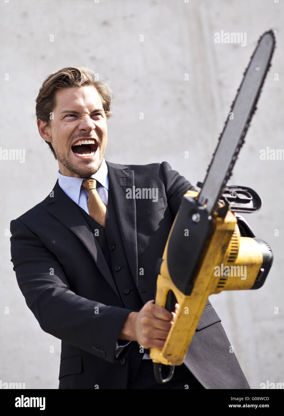 Angry businessman with blurred chainsaw Stock Photo