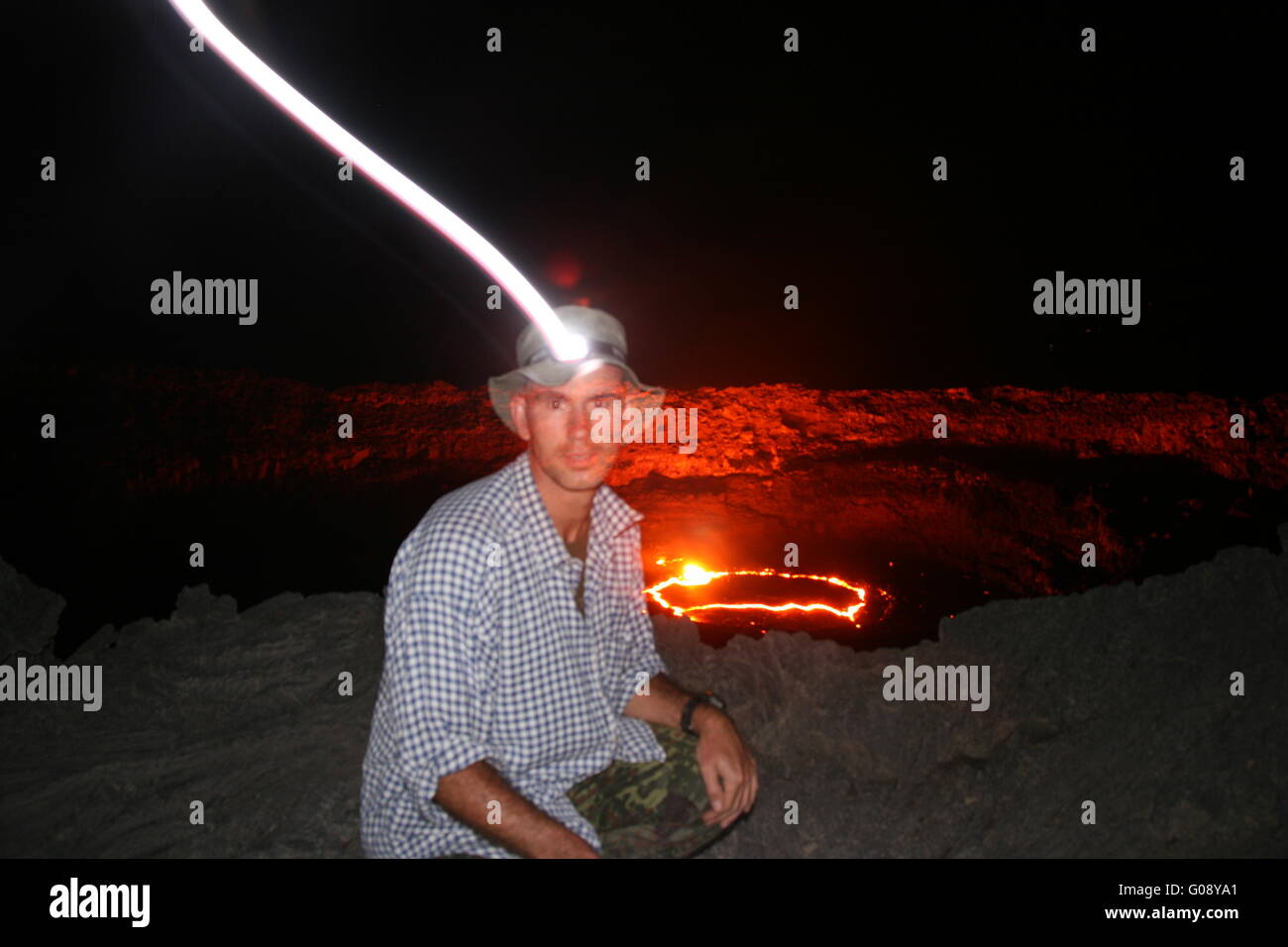Person with headlamp at Erta Ale volcano Stock Photo