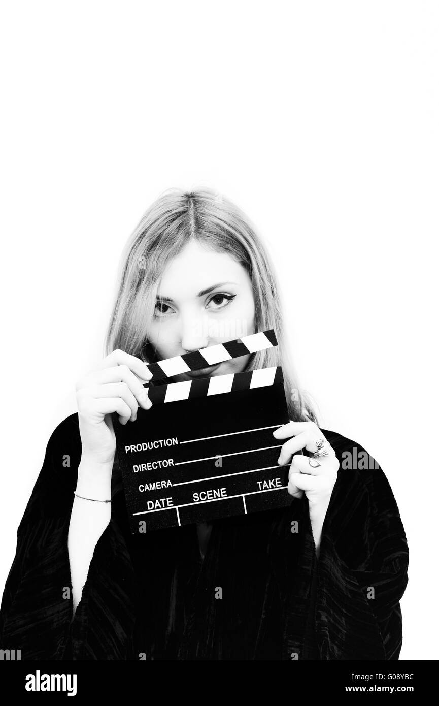 Young woman actress with movie clapper posing isolated in black and ...