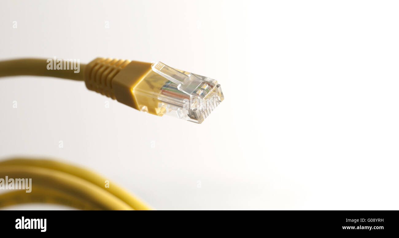 Yellow network cable with RJ45 connector on white Stock Photo