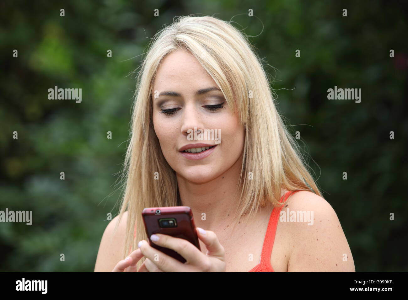 Attractive woman reading an sms on her mobile Stock Photo