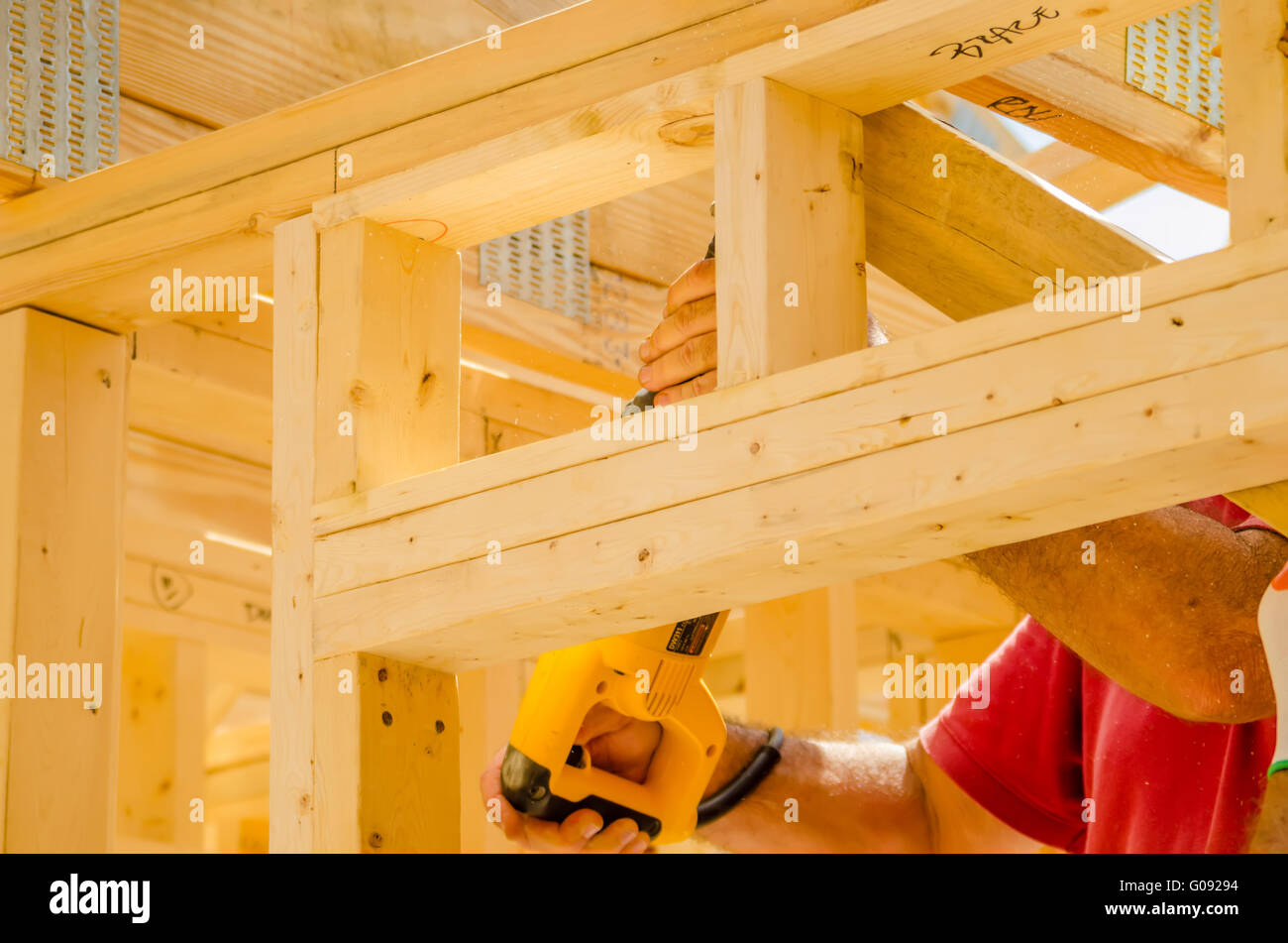 Building contractor worker using a reciprocating saw to cut Stock Photo