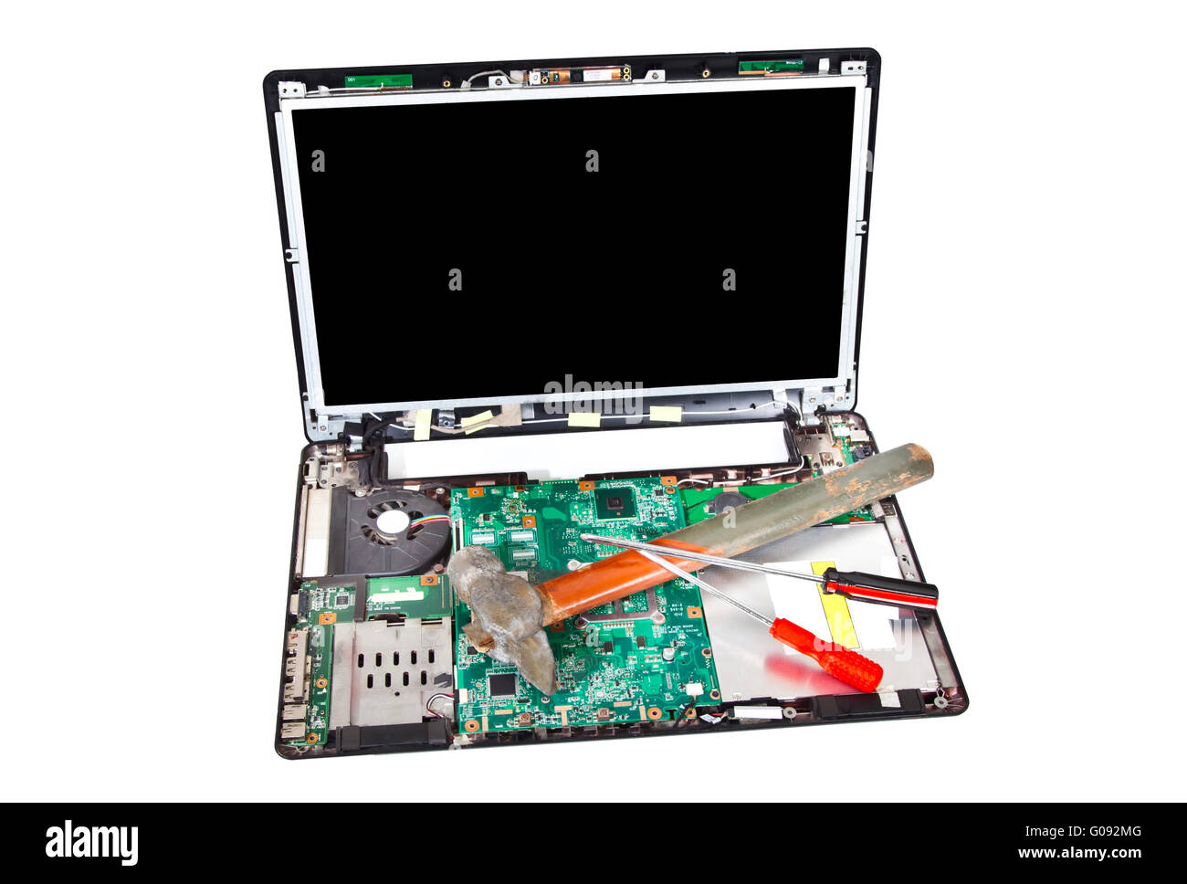 Laptop disassembled with hammer and screwdrivers on it Stock Photo