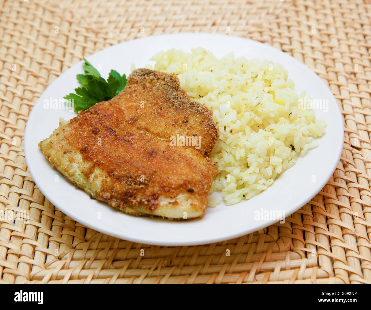 fried breaded tilapia served with rice and herbs Stock Photo Alamy