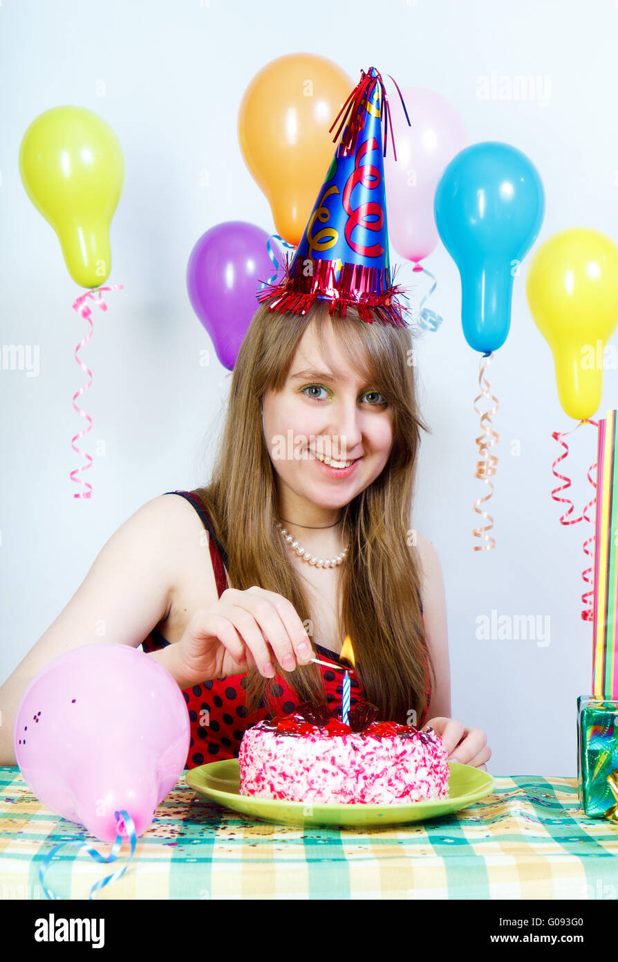 Birthday. Happy attractive girl lights a candle Stock Photo Alamy