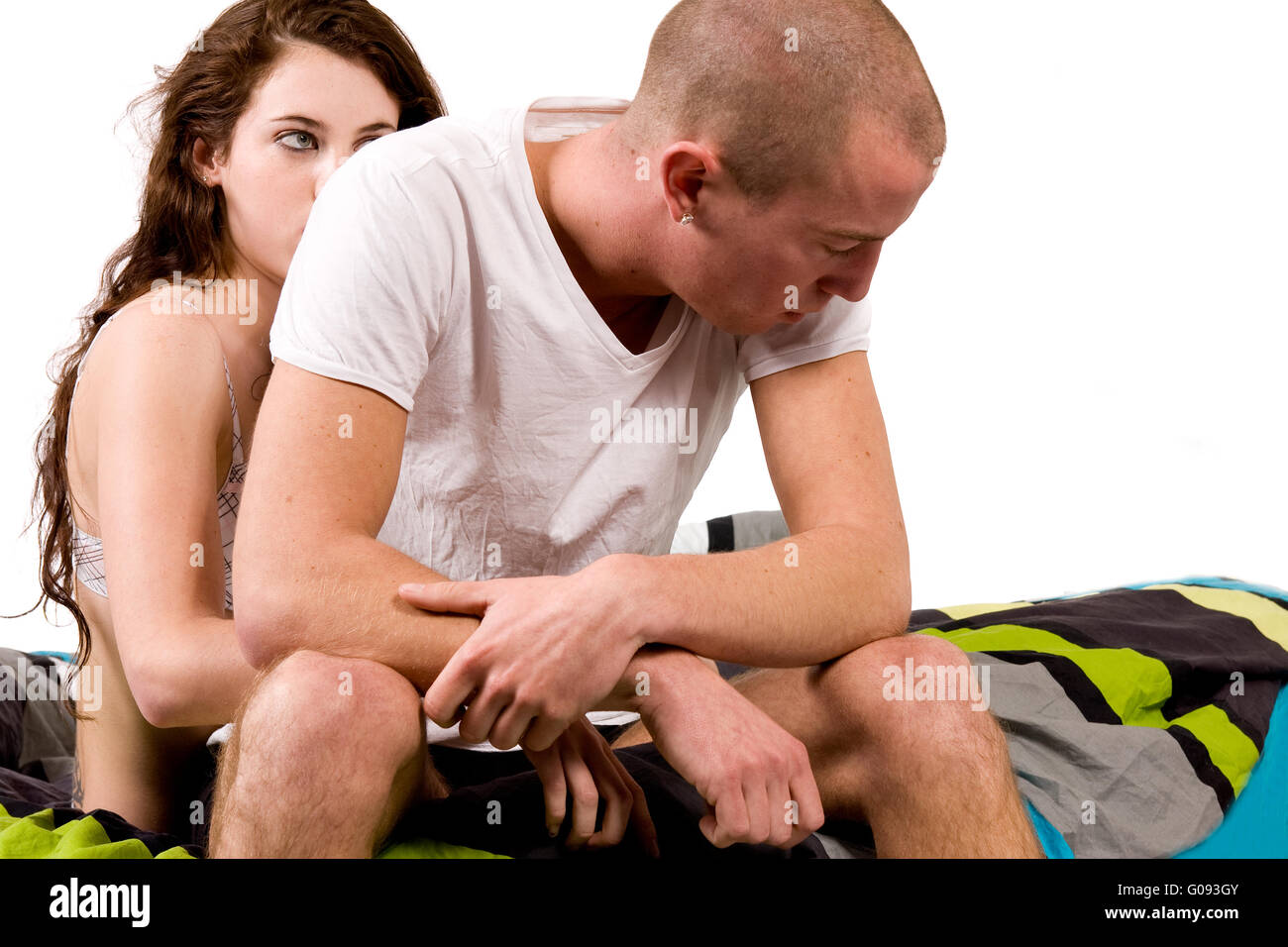 Young worried couple in bed with relational problems Stock Photo