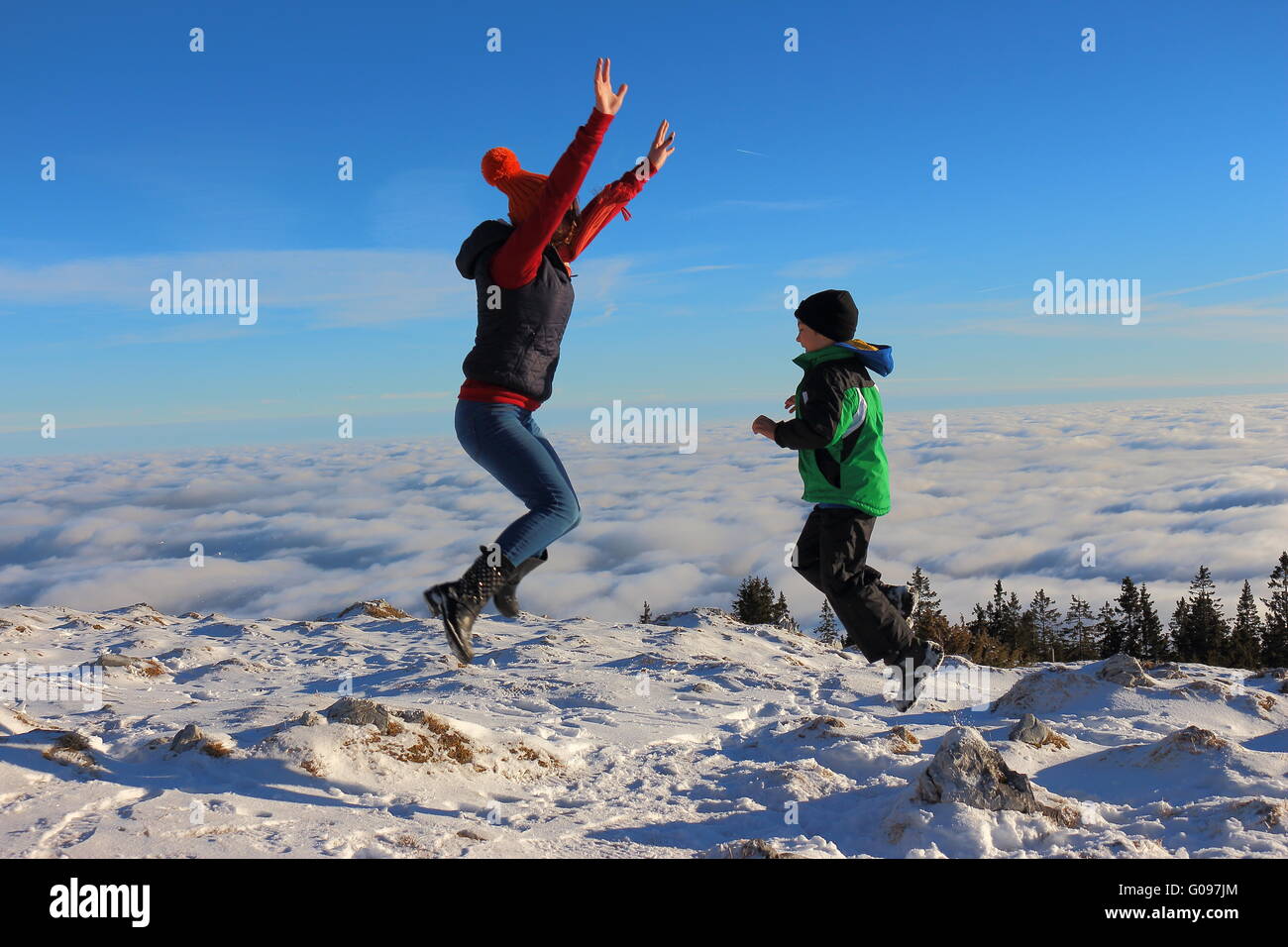 Child jumping in the air over the clouds Stock Photo