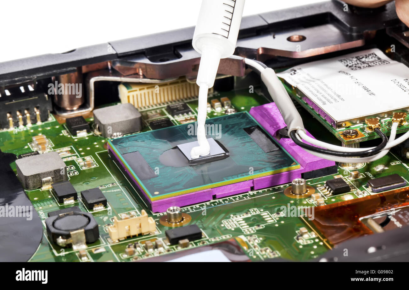 Thermal compound in syringe and laptop video chip Stock Photo