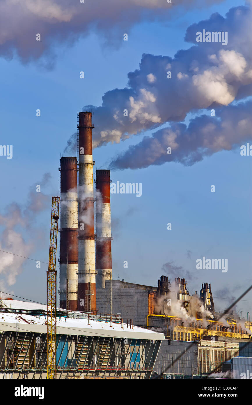 Thermal power station pipes smoke over a city. Stock Photo