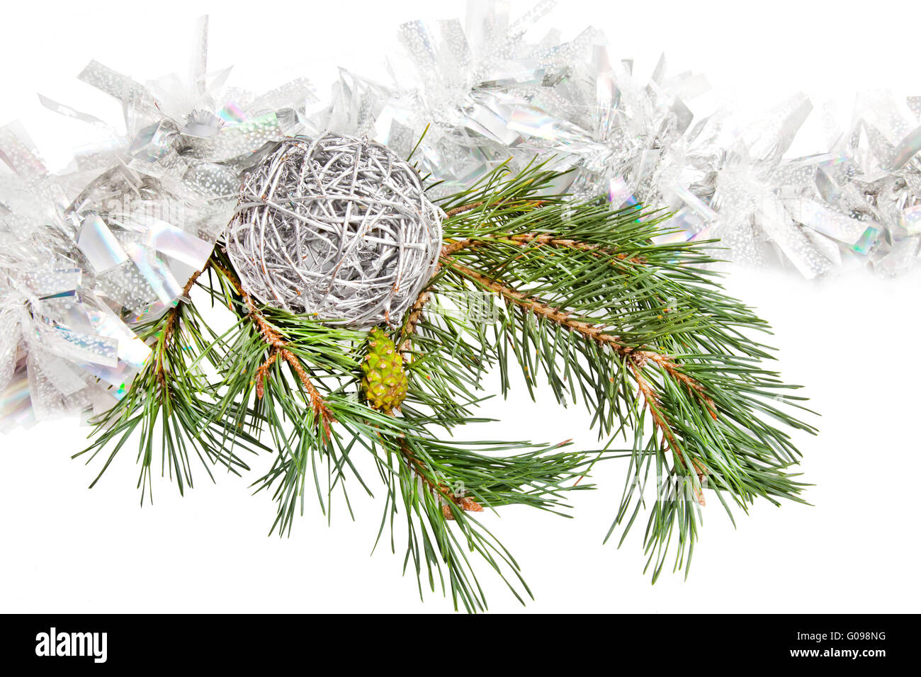 Green conifer branch with silver ball and tinsel Stock Photo