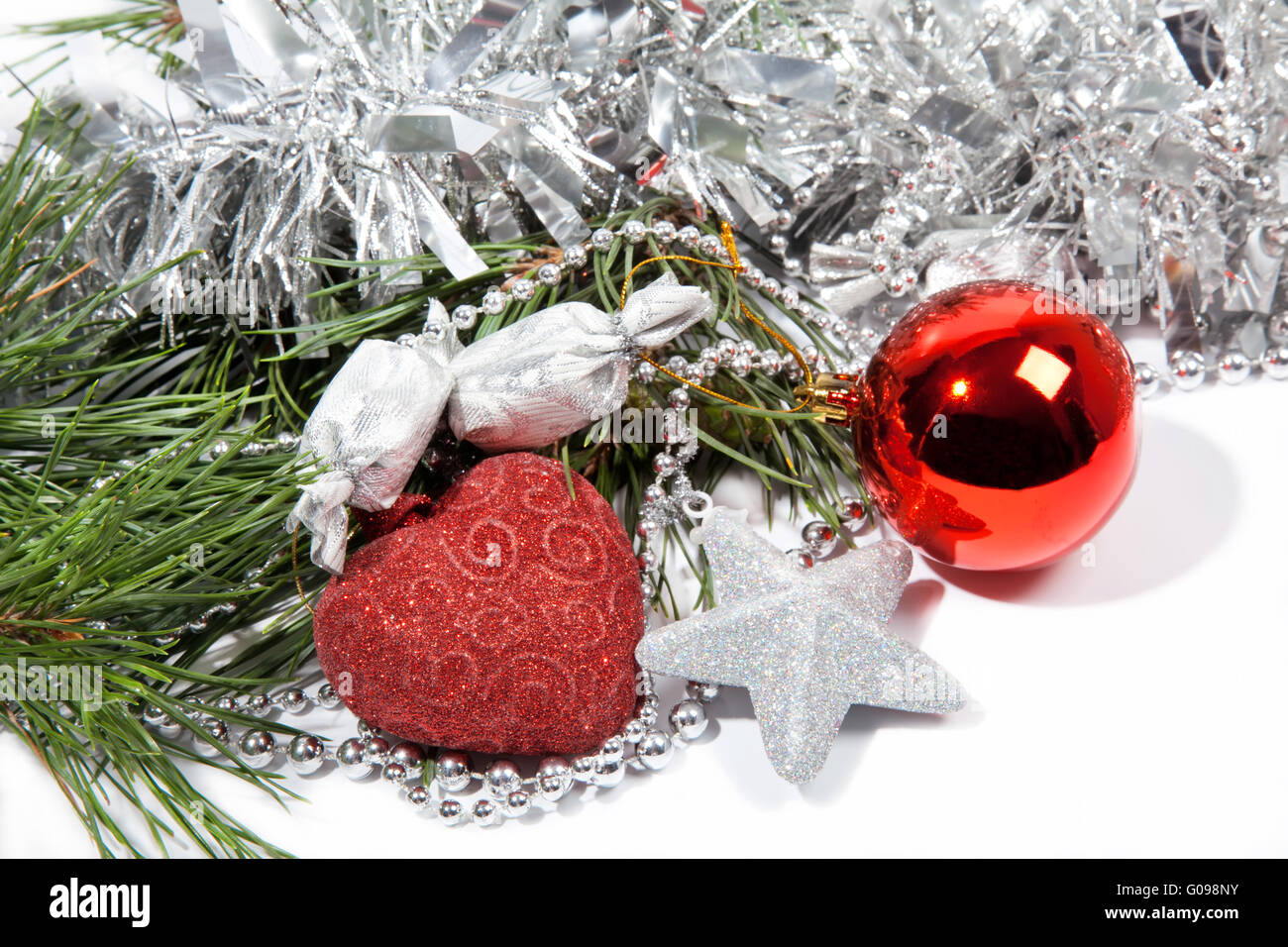 Red Christmas balls and silver star on pine branch Stock Photo