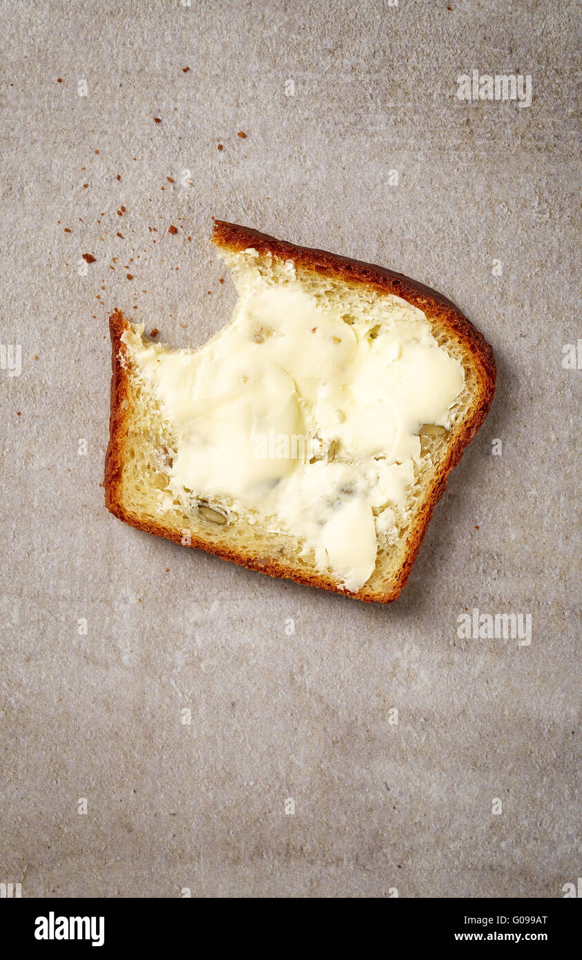 Butter spread on sliced healthy grain bread, top view Stock Photo