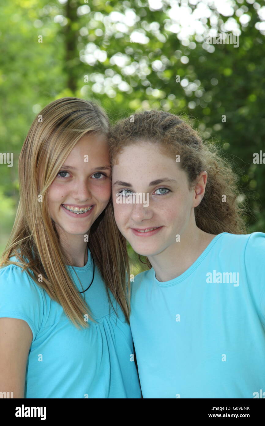 Two teenage girls smiling while posing together Stock Photo - Alamy