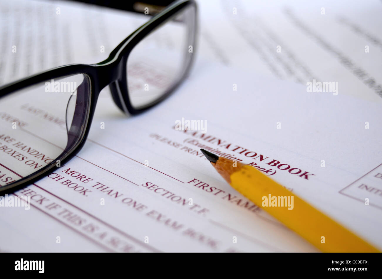 Close up of a pencil and some glasses on a university examination book Stock Photo