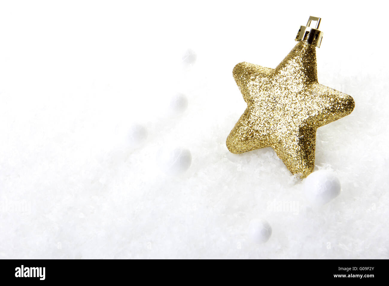 gold christmas bauble as christmas star on snow Stock Photo