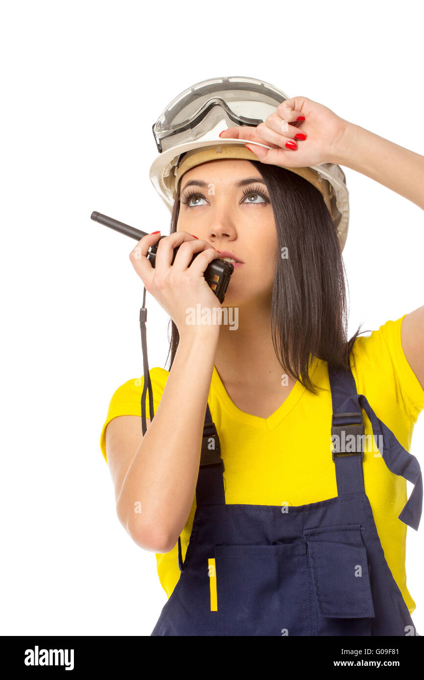 Serious female construction worker talking with a walkie talkie Stock Photo