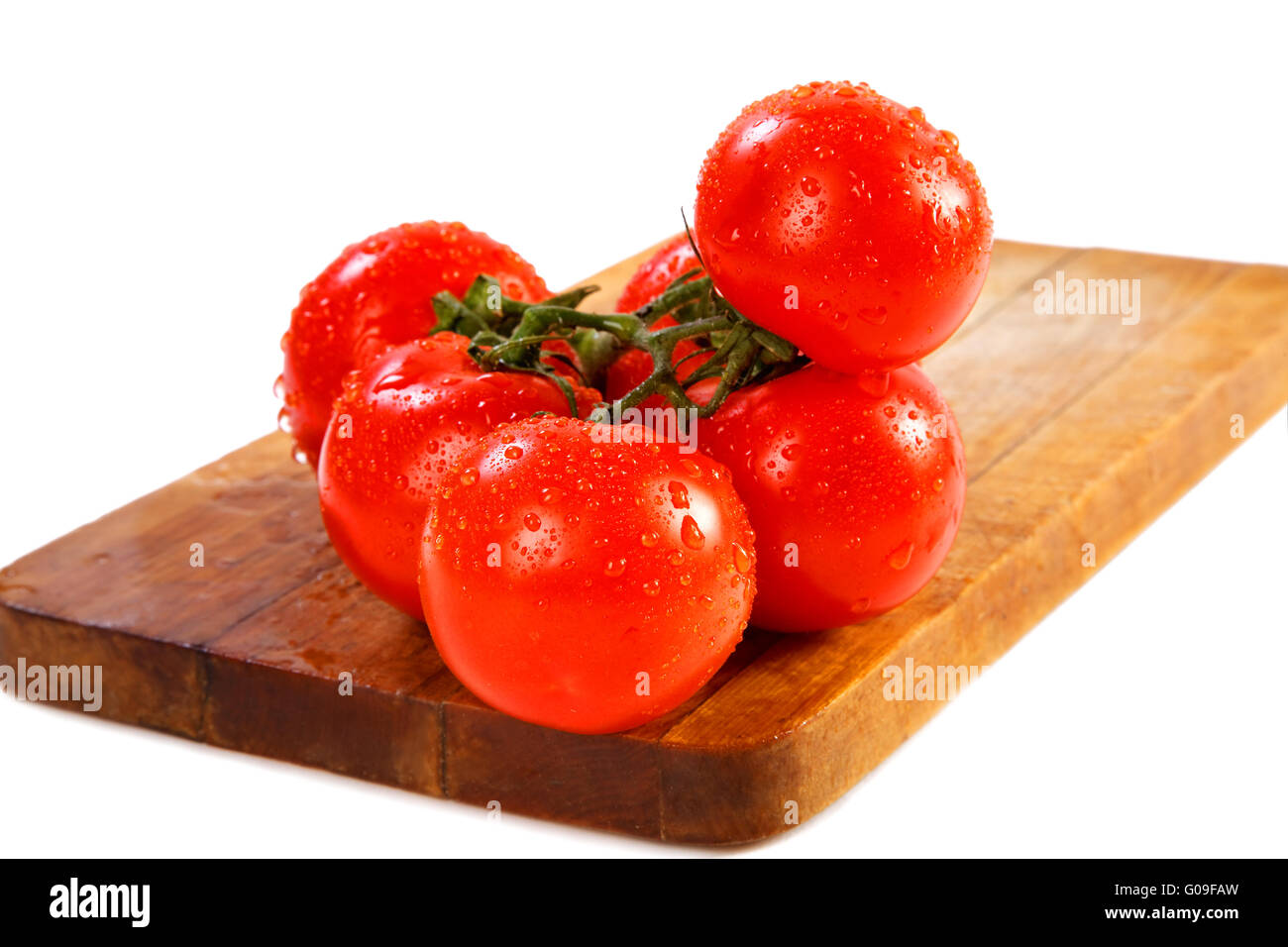 Branch of tomatoes with water drops on a white background Stock Photo ...