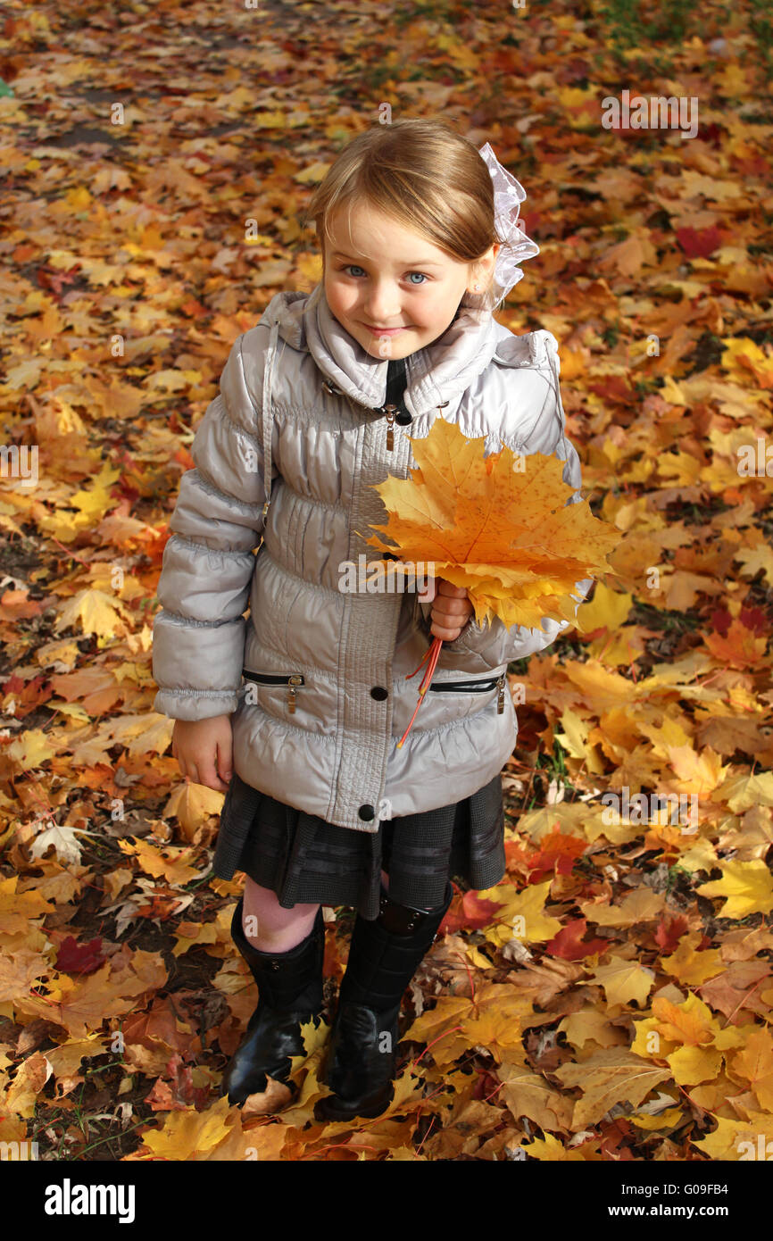 little girl with yellow leaf in the park in autumn Stock Photo - Alamy