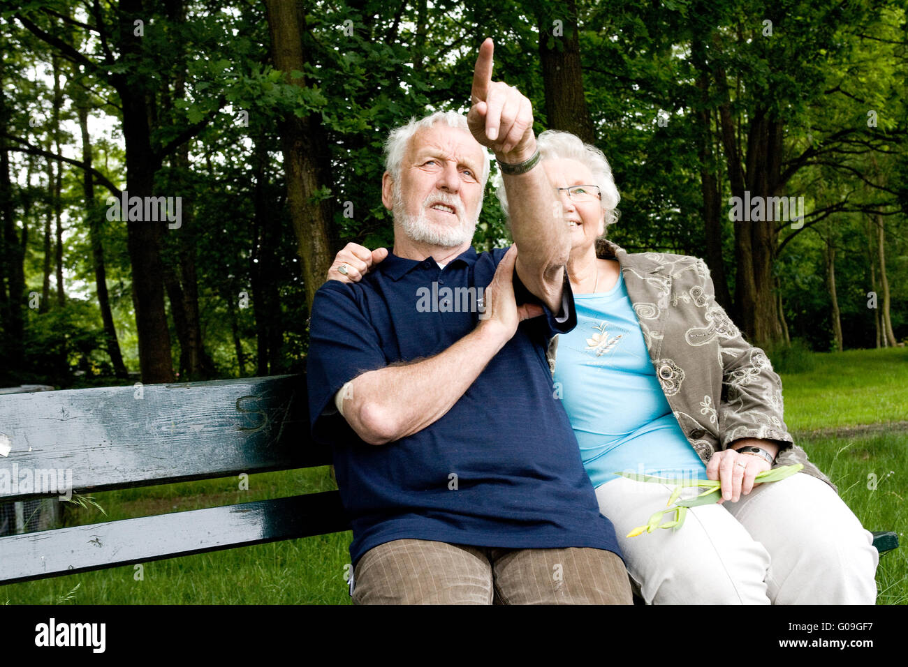 Couple sitting outside on a park bench Stock Photo - Alamy