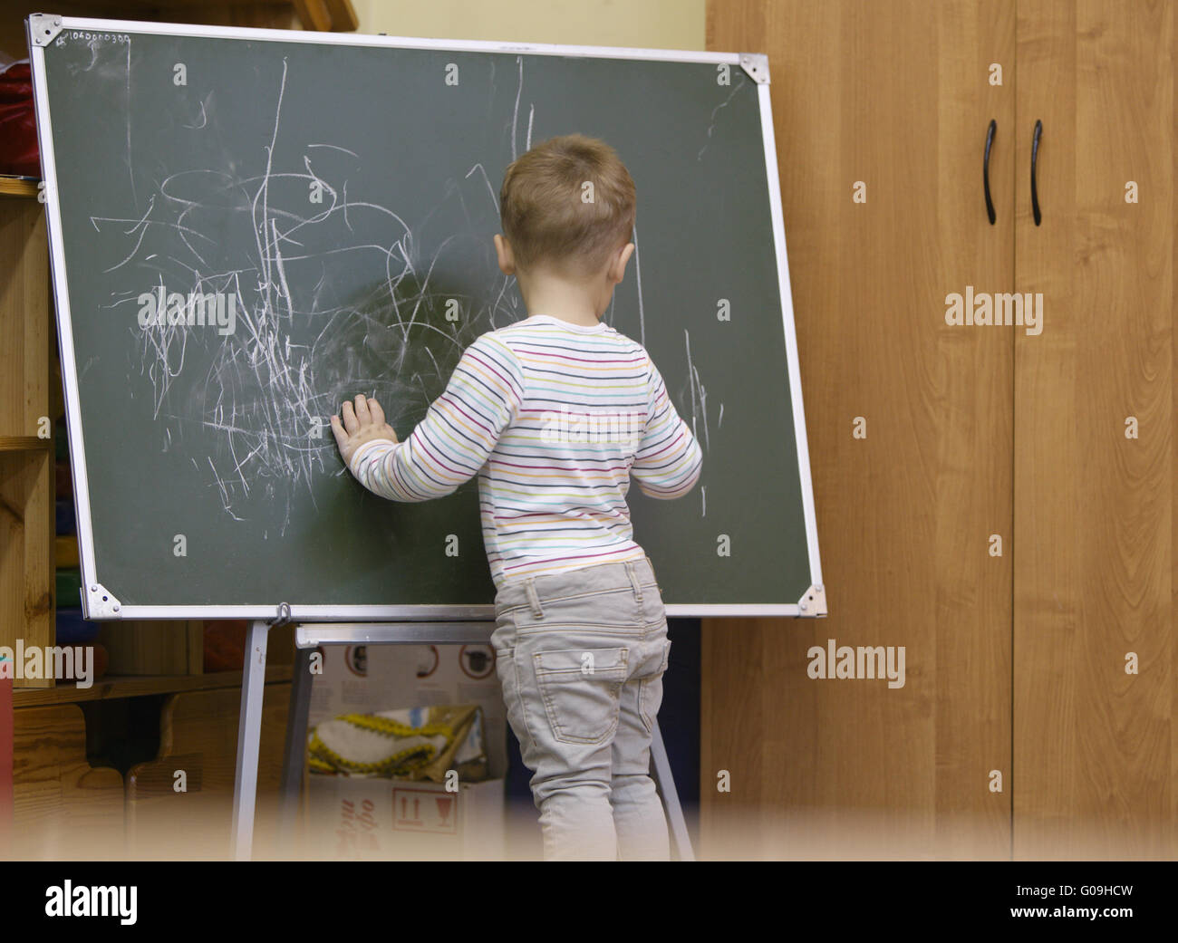 Little boy drawing on a chalkboard at kindergarten Stock Photo