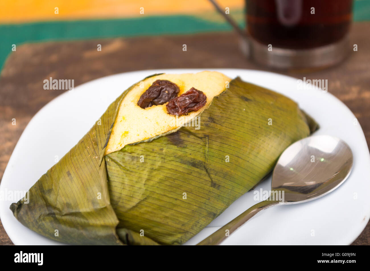 Delicious sweet rough with raisins wrapped in achira leaf served on a white dish, quimbolito Stock Photo
