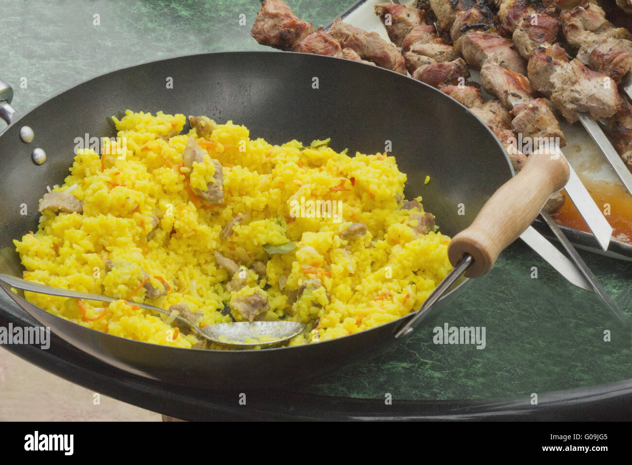 https://c8.alamy.com/comp/G09JG5/pilaf-in-a-large-frying-pan-and-grilled-kebabs-G09JG5.jpg