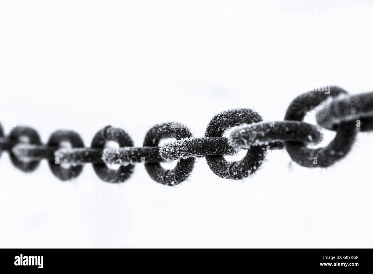 old rusty iron chain on a frost covered with snow Stock Photo