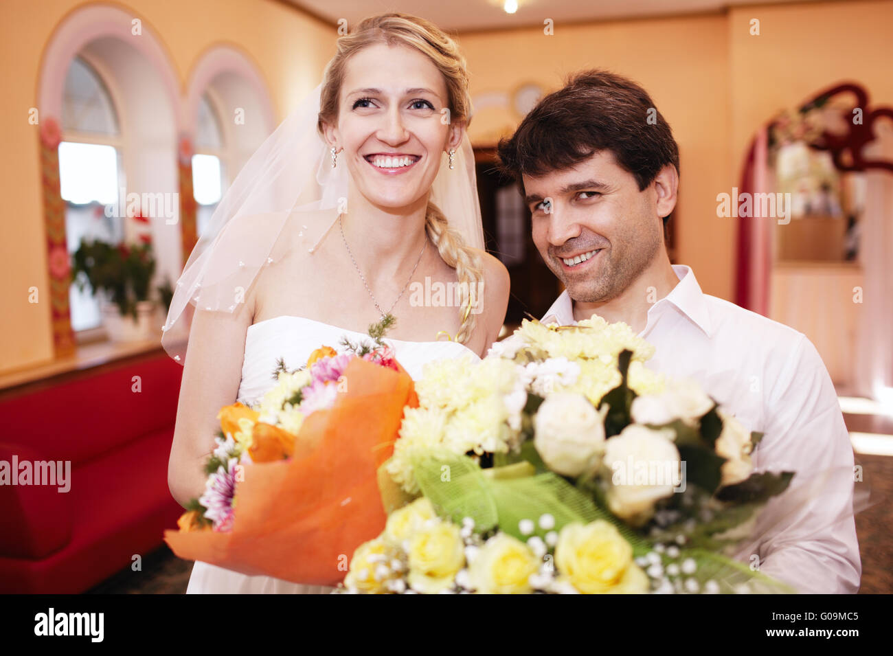 Smiling bride and groom with bouquets of flowers Stock Photo - Alamy