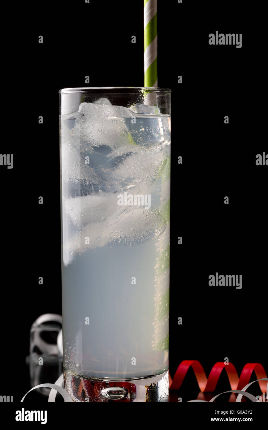 Collins glass with cocktails and colored straws. Decorated melted ice