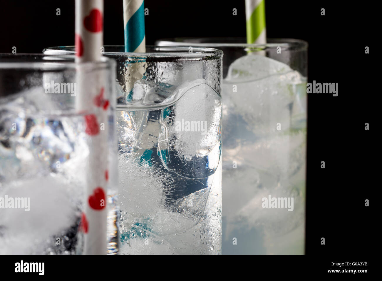 Set from three a collins glass with cocktails and colored straws