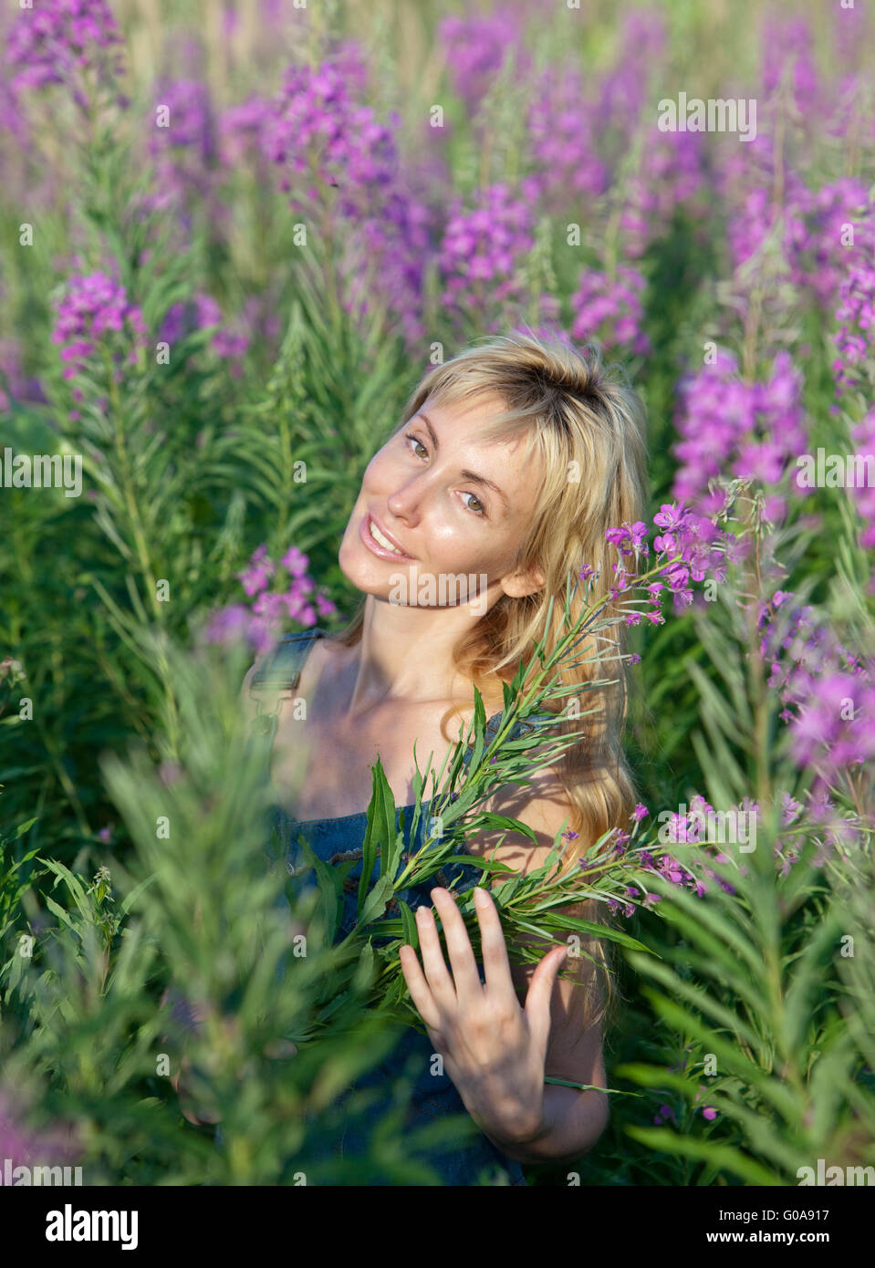 Portrait of the happy young woman in flowers bloom Stock Photo