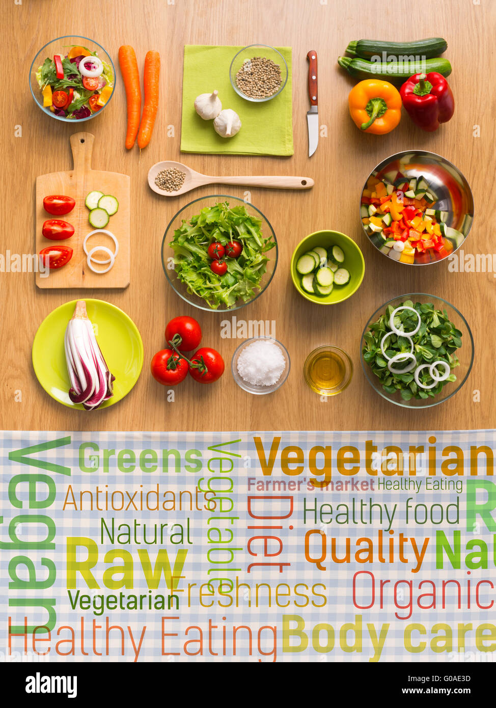 Healthy fresh vegetarian food on kitchen table with healthy eating text concepts on a checked tablecloth, top view Stock Photo